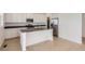 Open kitchen with white cabinets, stainless steel appliances, and a center island at 710 N Deer Park, Watkins, CO 80137