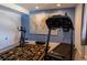 Home gym with exercise bike, treadmill, and a world map accent wall at 783 Calgary Way, Golden, CO 80401