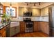 Charming kitchen with stainless steel appliances, a farmhouse sink, and black countertops at 783 Calgary Way, Golden, CO 80401