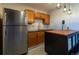 Kitchen with stainless steel refrigerator, breakfast bar, and rustic wooden cabinets at 783 Calgary Way, Golden, CO 80401