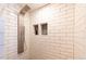 Modern shower featuring white subway tiles and dual recessed shower caddies at 783 Calgary Way, Golden, CO 80401