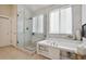 Spa-like bathroom with soaking tub, walk-in shower, and marble tile at 147 Chapel Hill Cir, Brighton, CO 80601