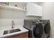 Modern laundry room with Samsung washer and dryer, and a utility sink at 147 Chapel Hill Cir, Brighton, CO 80601