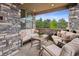 Covered patio with stone wall and comfortable seating area at 147 Chapel Hill Cir, Brighton, CO 80601