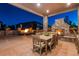 Evening view of patio with fire pit, fireplace, and dining area at 147 Chapel Hill Cir, Brighton, CO 80601