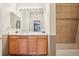 A bathroom with a large mirror and wooden vanity and a bathtub with tiled walls at 7160 S Wenatchee Way # F, Aurora, CO 80016