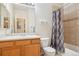 The bathroom with a vanity, toilet, and shower featuring decorative tile and a stylish shower curtain at 7160 S Wenatchee Way # F, Aurora, CO 80016
