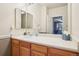 Bathroom with a sink, wooden vanity, large mirror, and view into the bedroom at 7160 S Wenatchee Way # F, Aurora, CO 80016