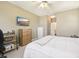 Bedroom with neutral walls, ceiling fan, wall-mounted tv, and ensuite bathroom access at 7160 S Wenatchee Way # F, Aurora, CO 80016