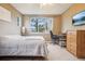 Bedroom featuring a window with views of the surrounding neighborhood, along with a workspace and a ceiling fan at 7160 S Wenatchee Way # F, Aurora, CO 80016
