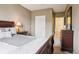 A neutral bedroom featuring dark wood furniture, a queen bed and natural light from the window at 7160 S Wenatchee Way # F, Aurora, CO 80016