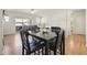 Dining area with seating for four, hardwood floors, and views of the bright living area and the outdoors at 7160 S Wenatchee Way # F, Aurora, CO 80016