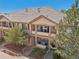 A tan home features a tile roof, stone pillars on the balcony, and a well-maintained yard at 7160 S Wenatchee Way # F, Aurora, CO 80016