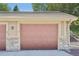 Garage door with brick and siding; unit labeled 