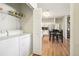 View of laundry, kitchen, and dining area with hardwood floors and stainless steel appliances at 7160 S Wenatchee Way # F, Aurora, CO 80016