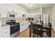 Well-lit kitchen featuring white cabinets, stainless steel appliances, and adjacent dark wood dining table at 7160 S Wenatchee Way # F, Aurora, CO 80016