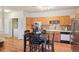 This is an open kitchen featuring wooden cabinets, tile backsplash, black appliances, and dining table at 7160 S Wenatchee Way # F, Aurora, CO 80016