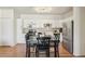 Bright kitchen with white cabinets, stainless steel appliances, and a dark wood dining table for meals at 7160 S Wenatchee Way # F, Aurora, CO 80016