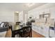 Bright kitchen with white cabinets, black appliances and a dark wood dining table with seating for four at 7160 S Wenatchee Way # F, Aurora, CO 80016
