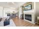 Open-concept living area with fireplace, TV, and hardwood floors flowing into the adjacent modern kitchen at 7160 S Wenatchee Way # F, Aurora, CO 80016