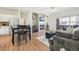 Open-concept living area with a fireplace, flat-screen TV, and hardwood floors leading to the kitchen at 7160 S Wenatchee Way # F, Aurora, CO 80016