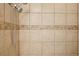 Shower stall featuring shower head with beige tile surround and decorative tile border at 7160 S Wenatchee Way # F, Aurora, CO 80016