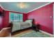 Red bedroom featuring a comfortable bed, a window, a rug, and a modern light fixture at 6260 W 45Th Pl, Wheat Ridge, CO 80033