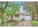 Attractive home with a detached garage and a well-maintained driveway nestled amid established trees and landscaping at 6260 W 45Th Pl, Wheat Ridge, CO 80033