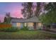 Attractive home with a neat lawn, mature trees, and tidy landscaping, enhancing its curb appeal at twilight at 6260 W 45Th Pl, Wheat Ridge, CO 80033