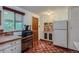 Cozy kitchen featuring ample cabinet space, stainless fridge and unique vintage floor tiling at 6260 W 45Th Pl, Wheat Ridge, CO 80033