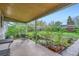 View of the covered patio, garden, pond, and lush backyard area at 6260 W 45Th Pl, Wheat Ridge, CO 80033