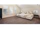 Bright bedroom with three large windows, neutral walls, gray carpet and comfortable upholstered bed at 875 Coal Bank Trl, Castle Rock, CO 80104