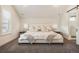 Bright bedroom featuring a plush bed, gray carpet, and ensuite bathroom with sliding barn door at 875 Coal Bank Trl, Castle Rock, CO 80104