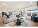 Bright living room featuring an open floor plan, comfortable seating, and natural light from expansive windows at 875 Coal Bank Trl, Castle Rock, CO 80104