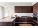 Sleek kitchen featuring dark wood cabinets, granite countertops, stainless steel appliances, and modern lighting at 4200 W 17Th Ave # 419, Denver, CO 80204