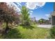 Picturesque backyard with lush green lawn, mature trees, and a charming fence at 9380 Bear River St, Littleton, CO 80125