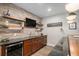Basement bar area featuring a brick accent wall, wood cabinets and shelving at 9380 Bear River St, Littleton, CO 80125