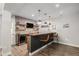 Finished basement bar with wood countertop, brick accent wall, and pendant lighting at 9380 Bear River St, Littleton, CO 80125