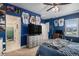 Blue accent bedroom features TV, jerseys and ample storage at 9380 Bear River St, Littleton, CO 80125
