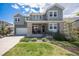Inviting two-story home with a stone facade, manicured lawn, and a welcoming front porch at 9380 Bear River St, Littleton, CO 80125