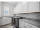 Well-equipped laundry room with ample cabinet space, countertop, and modern washer and dryer at 9380 Bear River St, Littleton, CO 80125