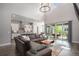 Open-concept living room with a large sectional sofa and view to a well-appointed kitchen and outdoor patio at 9380 Bear River St, Littleton, CO 80125