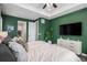 Well-lit main bedroom with a green accent wall and en-suite bathroom and walk-in closet at 9380 Bear River St, Littleton, CO 80125