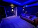 Home theater room with blue lighting, wall sconces, and comfortable seating at 9380 Bear River St, Littleton, CO 80125