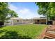Beautiful backyard with well-maintained lawn, a deck, and a matching detached garage at 2582 S Uno Way, Denver, CO 80219