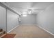 An unfinished basement area, showing neutral walls and carpet, along with a ceiling fan and small window at 2582 S Uno Way, Denver, CO 80219