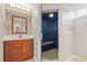 Bathroom features a wood vanity with a white sink, a mirror and a shower with blue tiling at 2582 S Uno Way, Denver, CO 80219