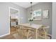 Dining room with modern lighting, light wood table and neutral paint, next to the kitchen at 2582 S Uno Way, Denver, CO 80219