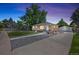 Inviting brick home with mature trees, well-manicured lawn, and a long driveway to a detached garage at 2582 S Uno Way, Denver, CO 80219