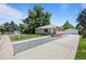 Charming brick home with well-kept front yard, large trees, and a long driveway to the detached garage at 2582 S Uno Way, Denver, CO 80219